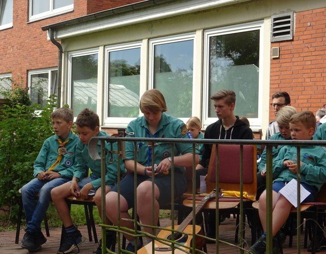 Pfadfinder sitzen auf einer Bank.