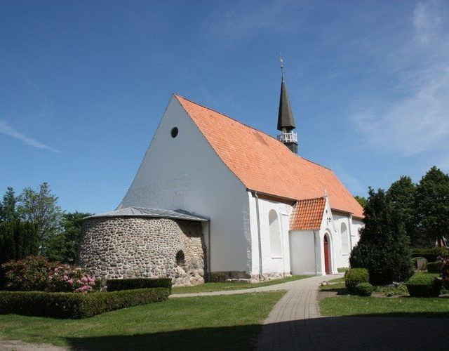 Weiße Kirche mit Steinturm.