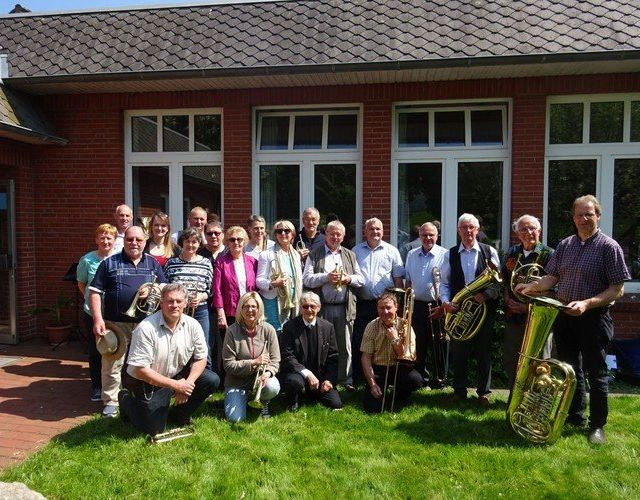 Gruppe von Erwachsenen vor einem Gebäude.