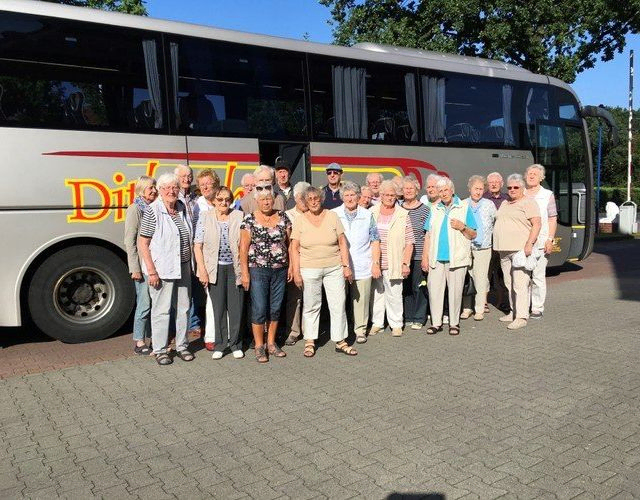 Gruppe von Menschen vor einem Reisebus.