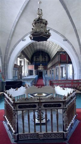 Kircheninnenraum mit Bögen und Empore.